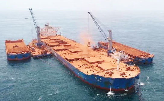 Bauxite is being uploaded from barge to large ship